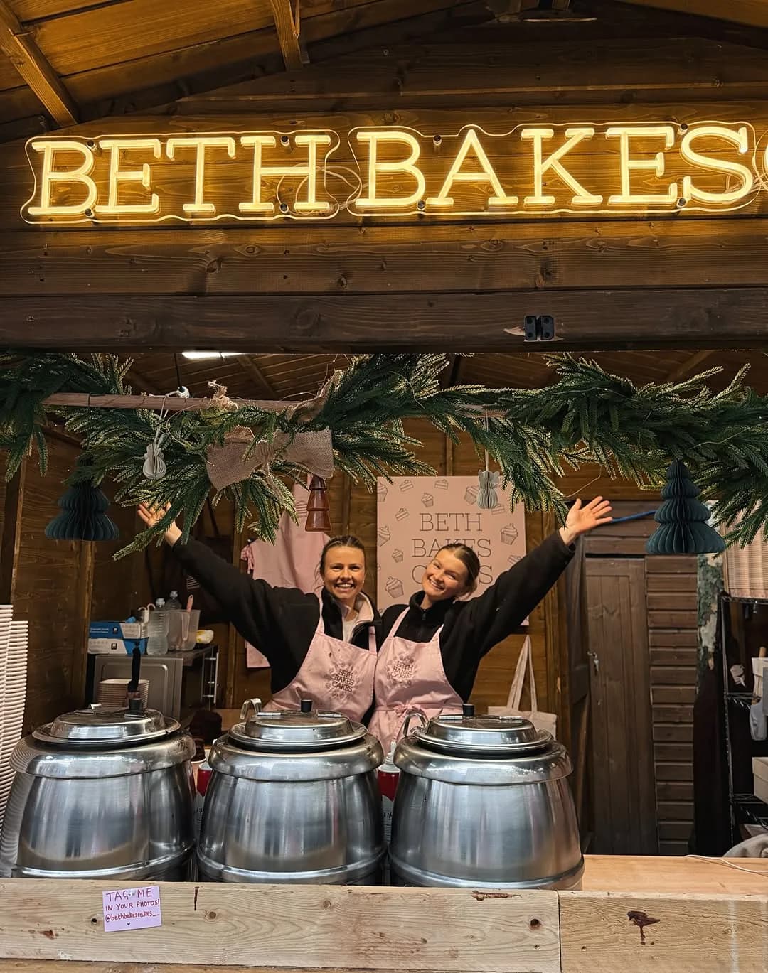 Beth and team under the BETH BAKES neon sign at Christmas market