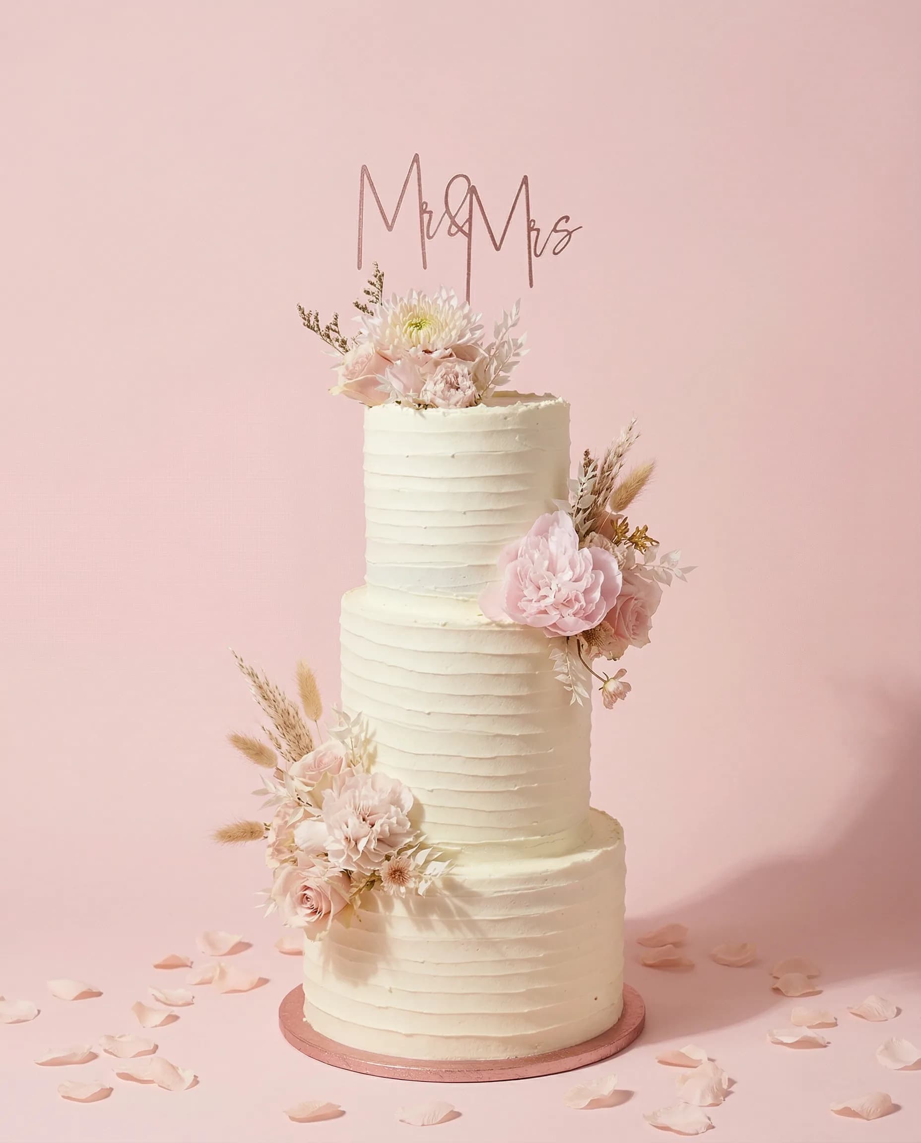 Three-tier ridged buttercream wedding cake with Mr & Mrs topper and pink peonies