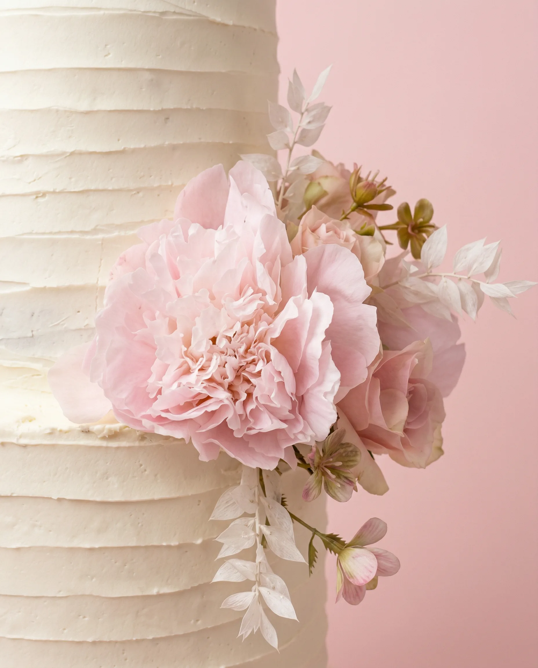 Detail shot of buttercream peonies on a wedding cake