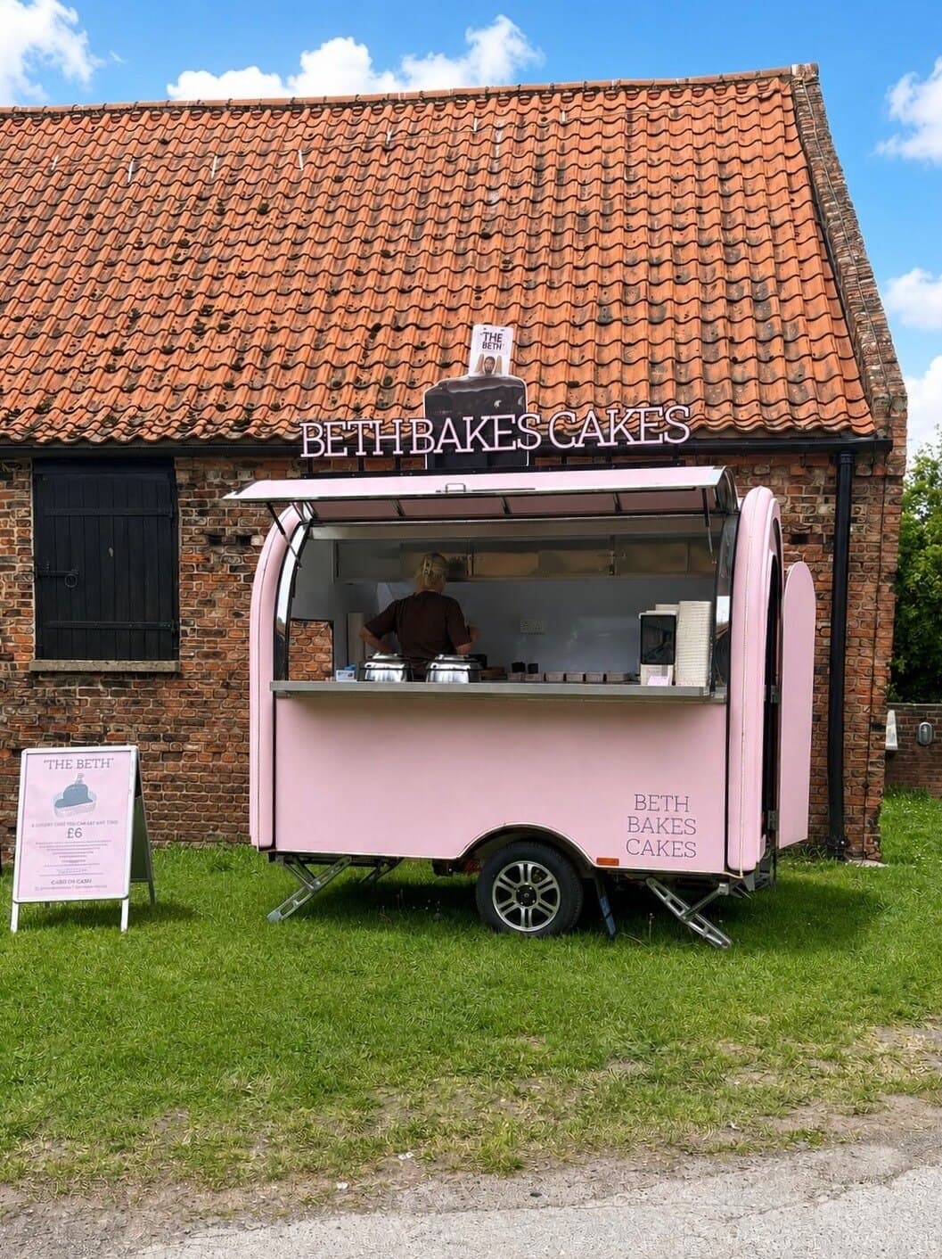 'The Beth' open and serving, pink trailer bar at a brick barn
